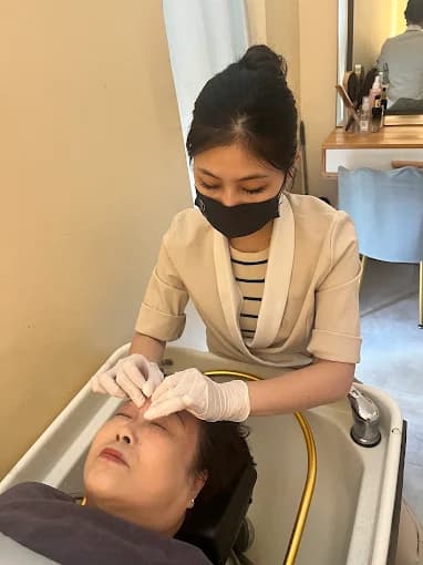 A therapist working through a head spa treatment at the wash basin